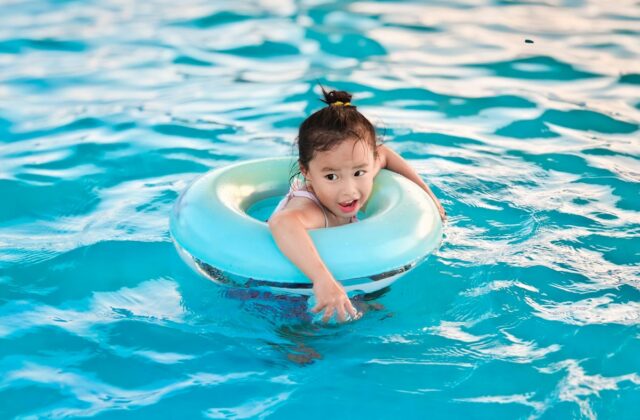 Young child floats in pool with inflatable ring