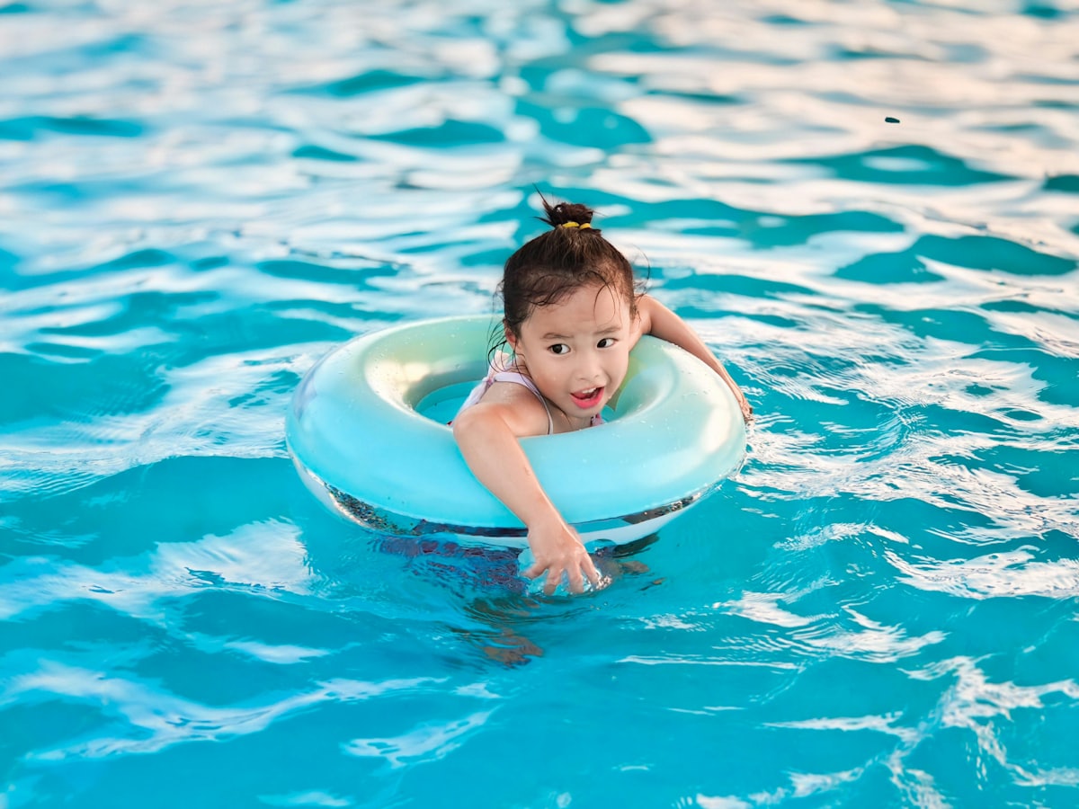 Young child floats in pool with inflatable ring