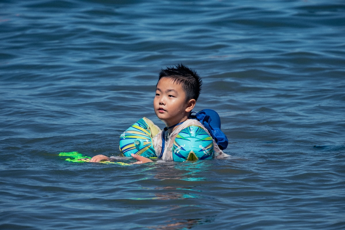 a boy playing with a ball in the water