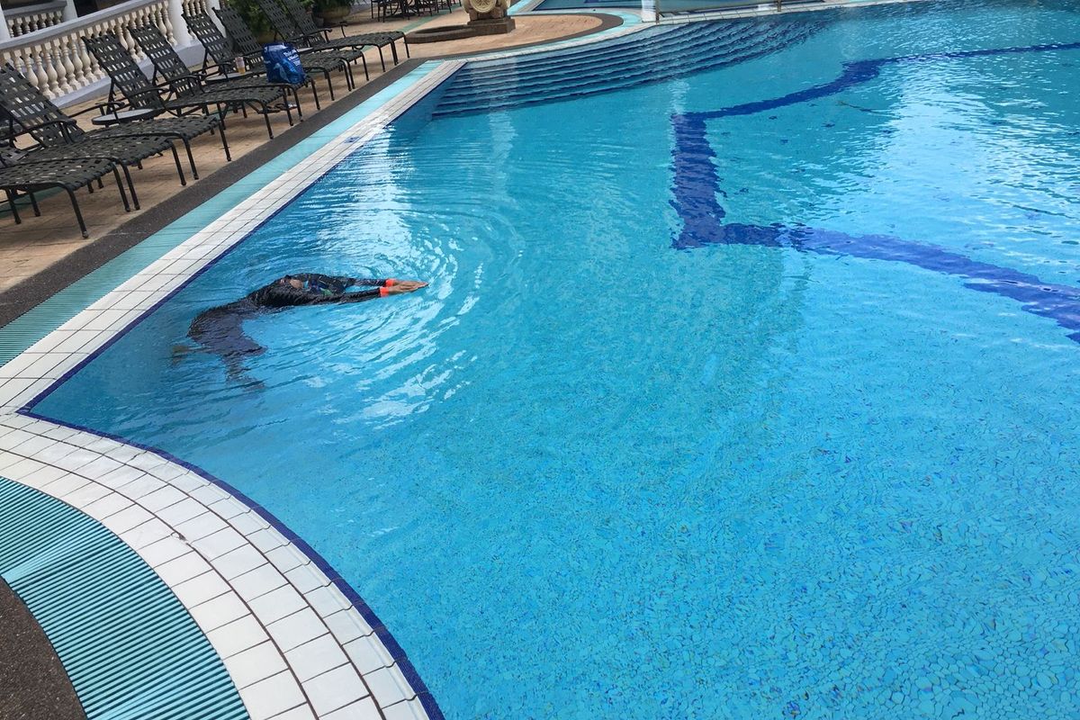 Swimmer gliding across a calm resort-style pool in Singapore